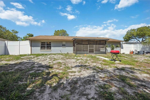 rear view of house featuring a sunroom