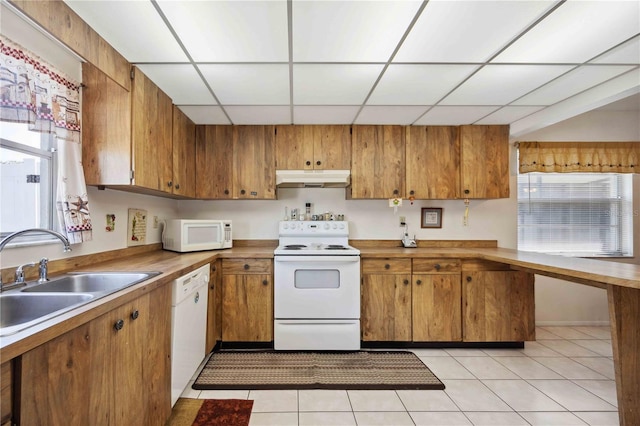 kitchen featuring light tile patterned flooring, white appliances, a paneled ceiling, and sink