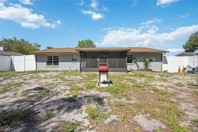 rear view of property featuring a sunroom