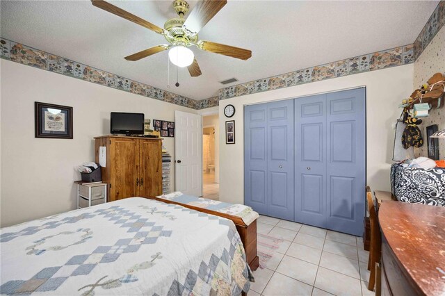 tiled bedroom featuring a textured ceiling, a closet, and ceiling fan