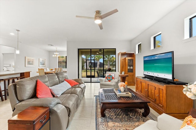 tiled living room with ceiling fan with notable chandelier and a wealth of natural light