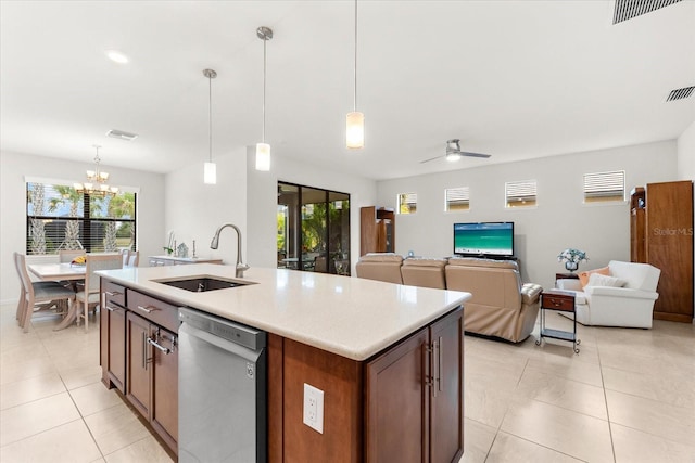 kitchen featuring light tile patterned flooring, sink, stainless steel dishwasher, pendant lighting, and a kitchen island with sink