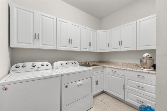 laundry room with cabinets, washer and dryer, and sink