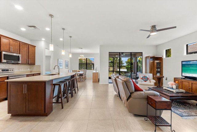 living room with ceiling fan with notable chandelier, sink, and light tile patterned floors