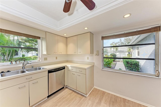 kitchen featuring sink, light wood-type flooring, ornamental molding, a tray ceiling, and dishwasher