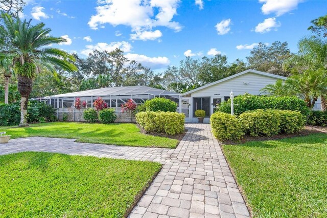 ranch-style home with a lanai and a front lawn