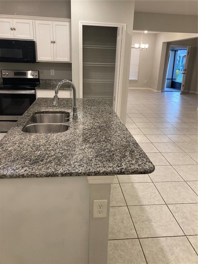 kitchen featuring sink, stainless steel range with electric stovetop, white cabinetry, light tile patterned flooring, and dark stone counters