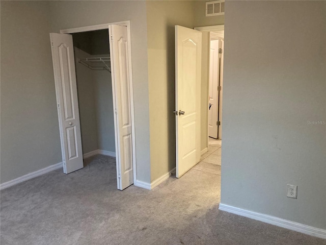 unfurnished bedroom featuring light colored carpet and a closet