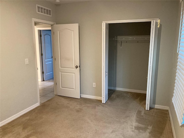 unfurnished bedroom featuring light colored carpet and a closet