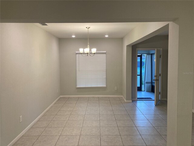 spare room featuring baseboards, light tile patterned flooring, visible vents, and an inviting chandelier