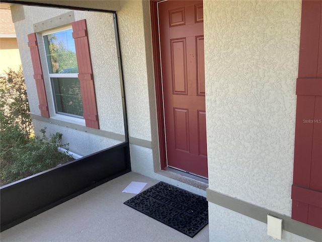 doorway to property featuring stucco siding