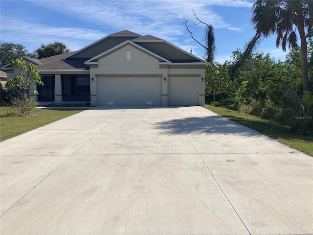 view of front of house with driveway, an attached garage, and stucco siding