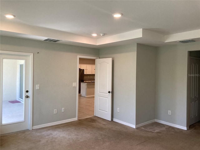 spare room with baseboards, recessed lighting, visible vents, and light colored carpet