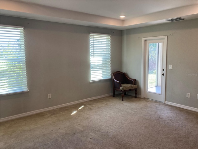 unfurnished room featuring light carpet, visible vents, and baseboards