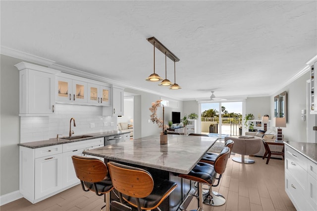 dining area featuring sink, crown molding, ceiling fan, light hardwood / wood-style floors, and a textured ceiling