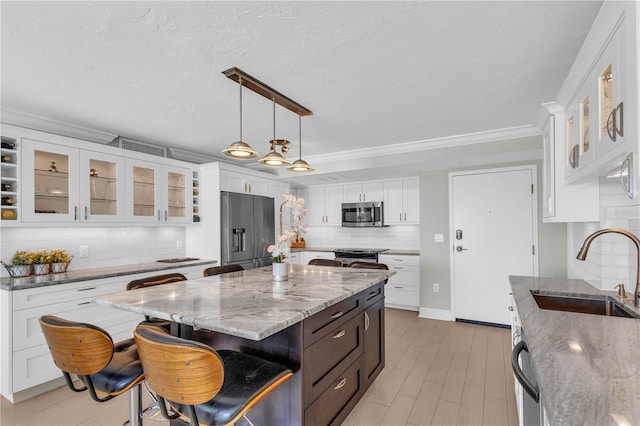 kitchen with a center island, appliances with stainless steel finishes, sink, and white cabinets