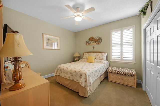 carpeted bedroom featuring ceiling fan, a closet, and a textured ceiling