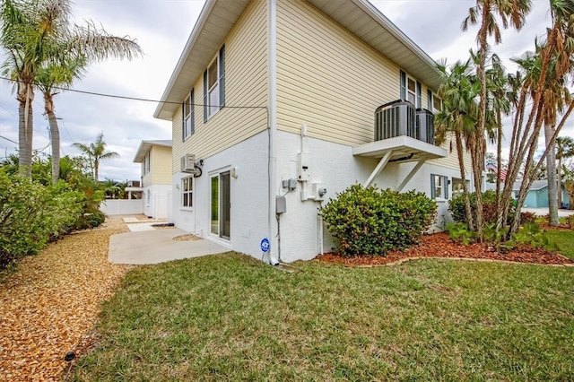 back of house with a yard, central AC unit, and a patio