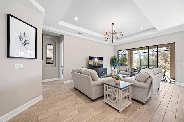 living room featuring an inviting chandelier and a tray ceiling