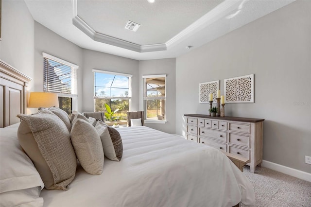 bedroom featuring ornamental molding, carpet flooring, and a raised ceiling