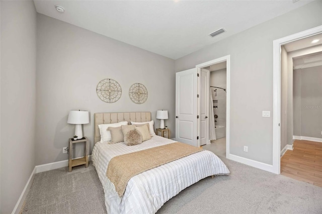 bedroom featuring ensuite bathroom and carpet flooring