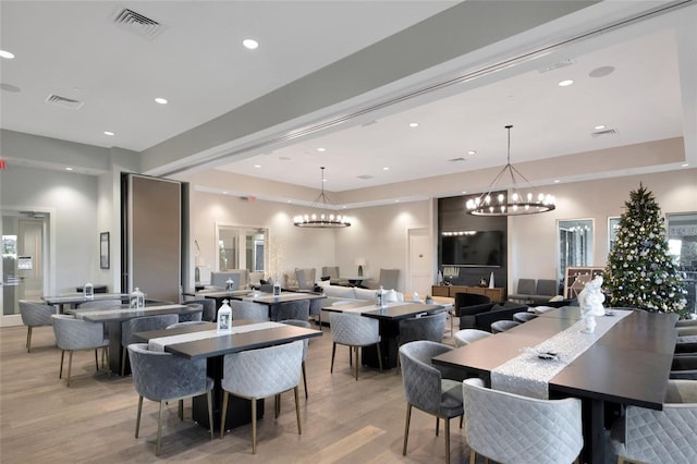 dining space with an inviting chandelier and light hardwood / wood-style floors