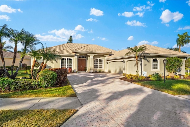 mediterranean / spanish-style home featuring a garage and a front lawn