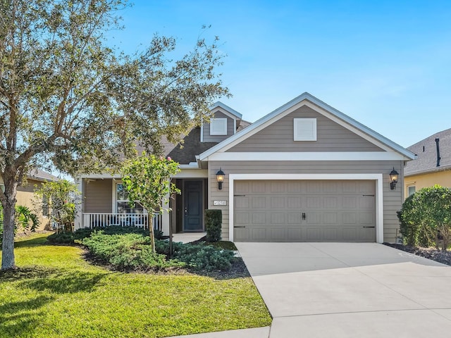 view of front of home featuring a garage, covered porch, and a front yard