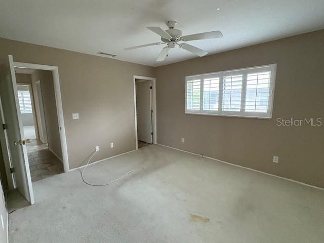 unfurnished bedroom with baseboards, visible vents, and ceiling fan