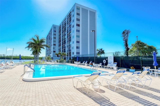 view of pool featuring a patio and a water view