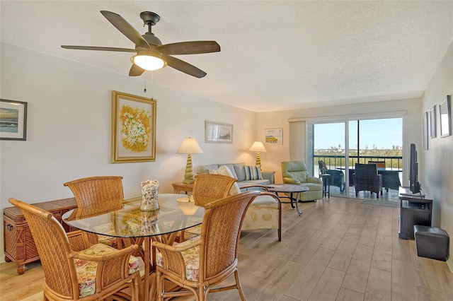 dining space featuring ceiling fan, light hardwood / wood-style flooring, and a textured ceiling