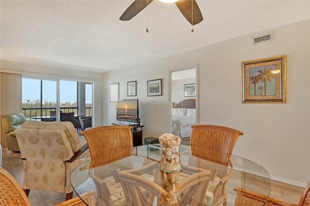 dining space featuring ceiling fan and a textured ceiling