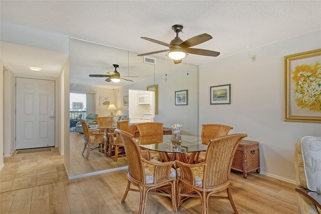 dining area featuring ceiling fan, a textured ceiling, and light wood-type flooring