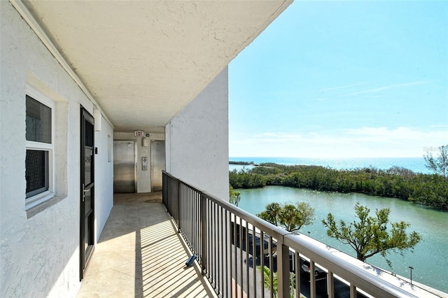 balcony with elevator and a water view