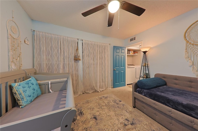 carpeted bedroom featuring washing machine and dryer, ceiling fan, and a textured ceiling