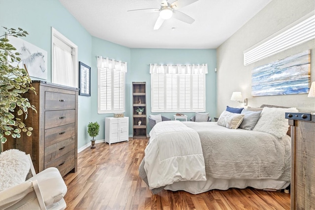 bedroom featuring ceiling fan, light wood-type flooring, and baseboards