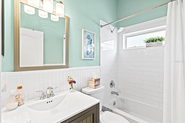 full bath with a wainscoted wall, vanity, shower / bath combination with curtain, and toilet