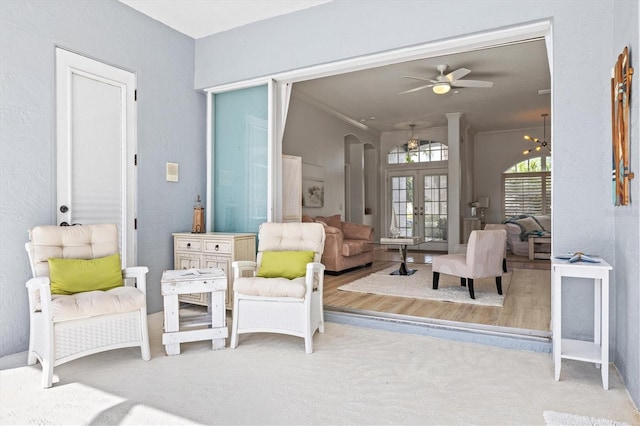 living area featuring ornamental molding, french doors, and a ceiling fan