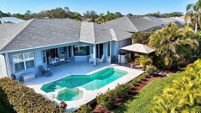 back of property featuring a pool with connected hot tub, roof with shingles, a patio, and stucco siding