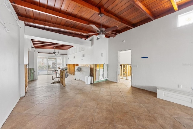 unfurnished room featuring beamed ceiling, ceiling fan, and plenty of natural light