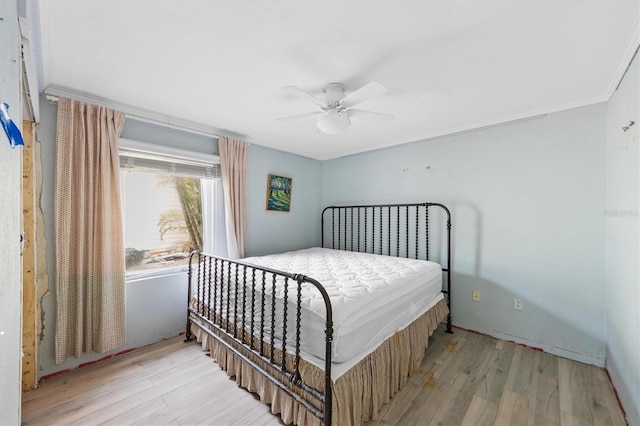 bedroom featuring crown molding, light hardwood / wood-style floors, and ceiling fan