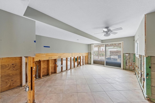 tiled empty room featuring a textured ceiling and ceiling fan