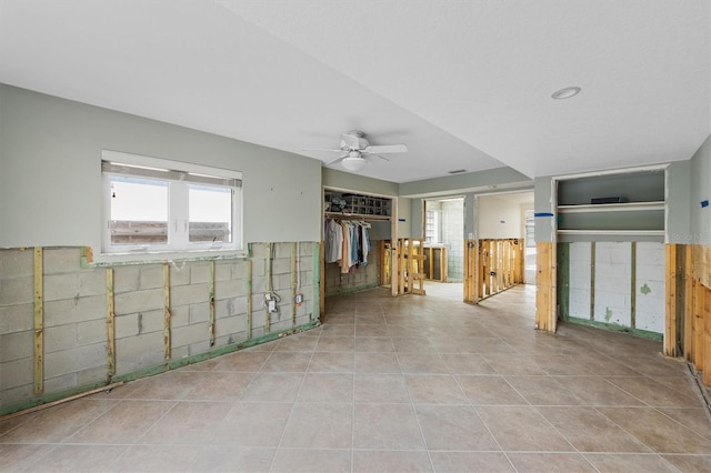 empty room with light tile patterned floors, plenty of natural light, and ceiling fan