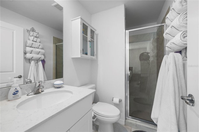 bathroom featuring vanity, a shower with door, and toilet