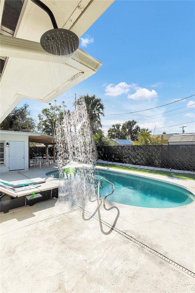 view of swimming pool with a patio and pool water feature