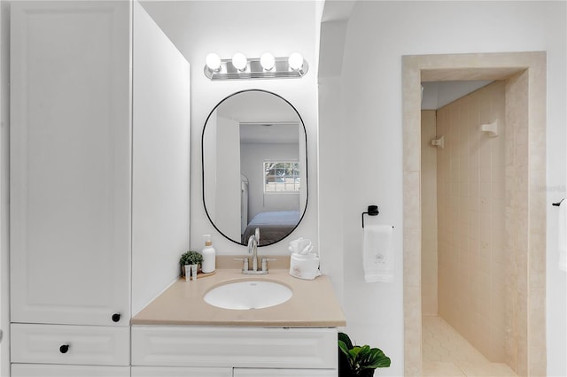 bathroom featuring a tile shower and vanity