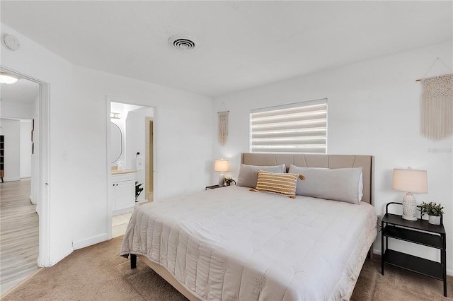 carpeted bedroom featuring ensuite bathroom