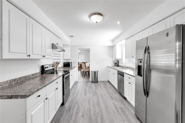 kitchen featuring light wood-type flooring, stainless steel appliances, sink, and white cabinets