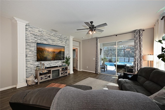 living room featuring ceiling fan, dark hardwood / wood-style floors, decorative columns, and a textured ceiling