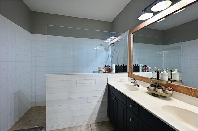 bathroom with tiled shower and vanity